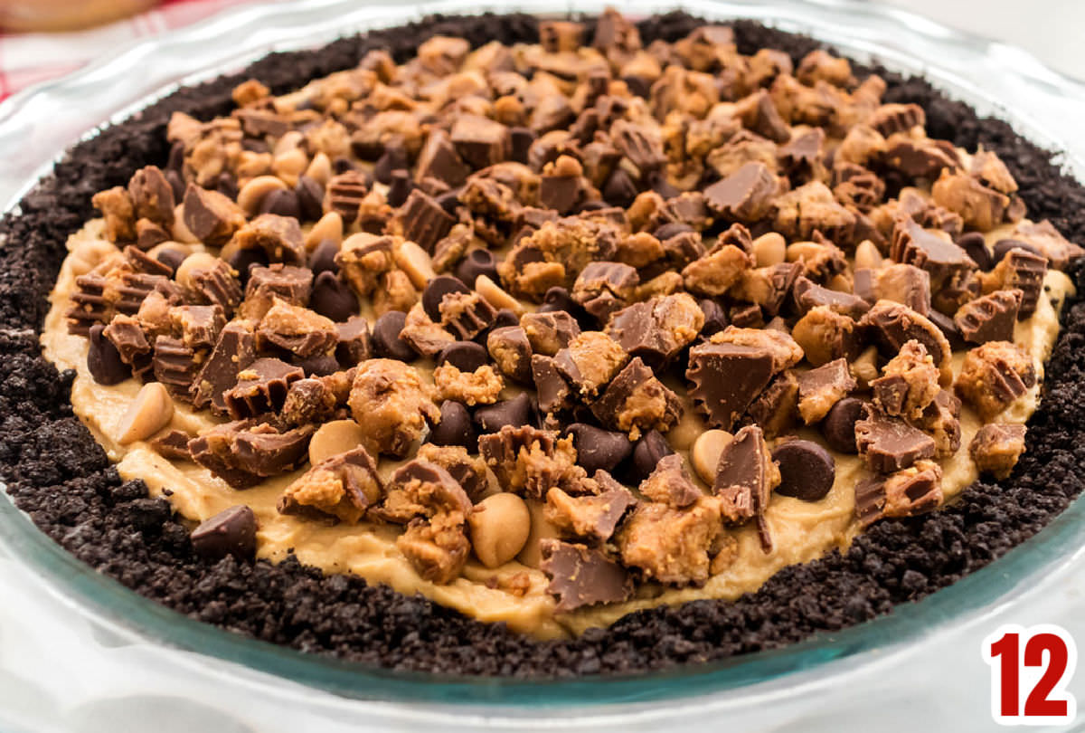 Closeup on the top of the No Bake Peanut Butter Pie showing the topping of Chopped Reese's Peanut Butter Cups, Chocolate Chips and Peanut Butter Chips.