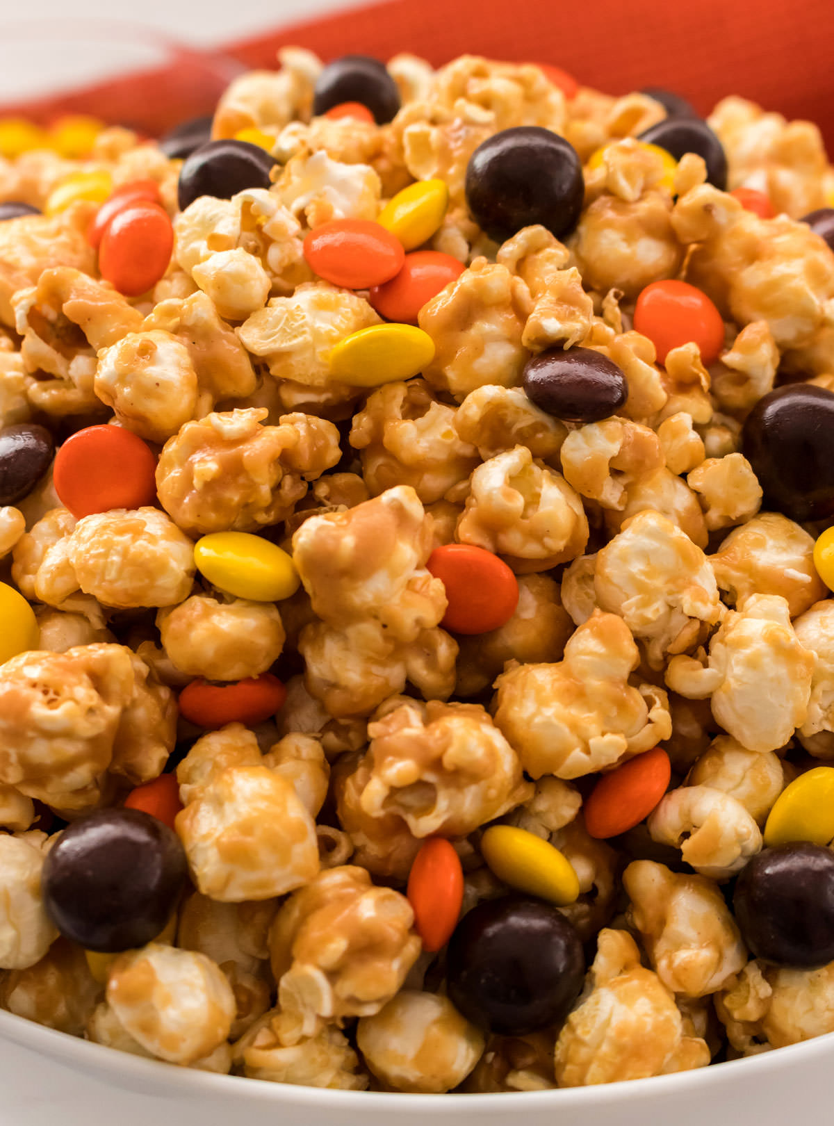 Closeup on a white serving bowl filled with Peanut Butter Popcorn.