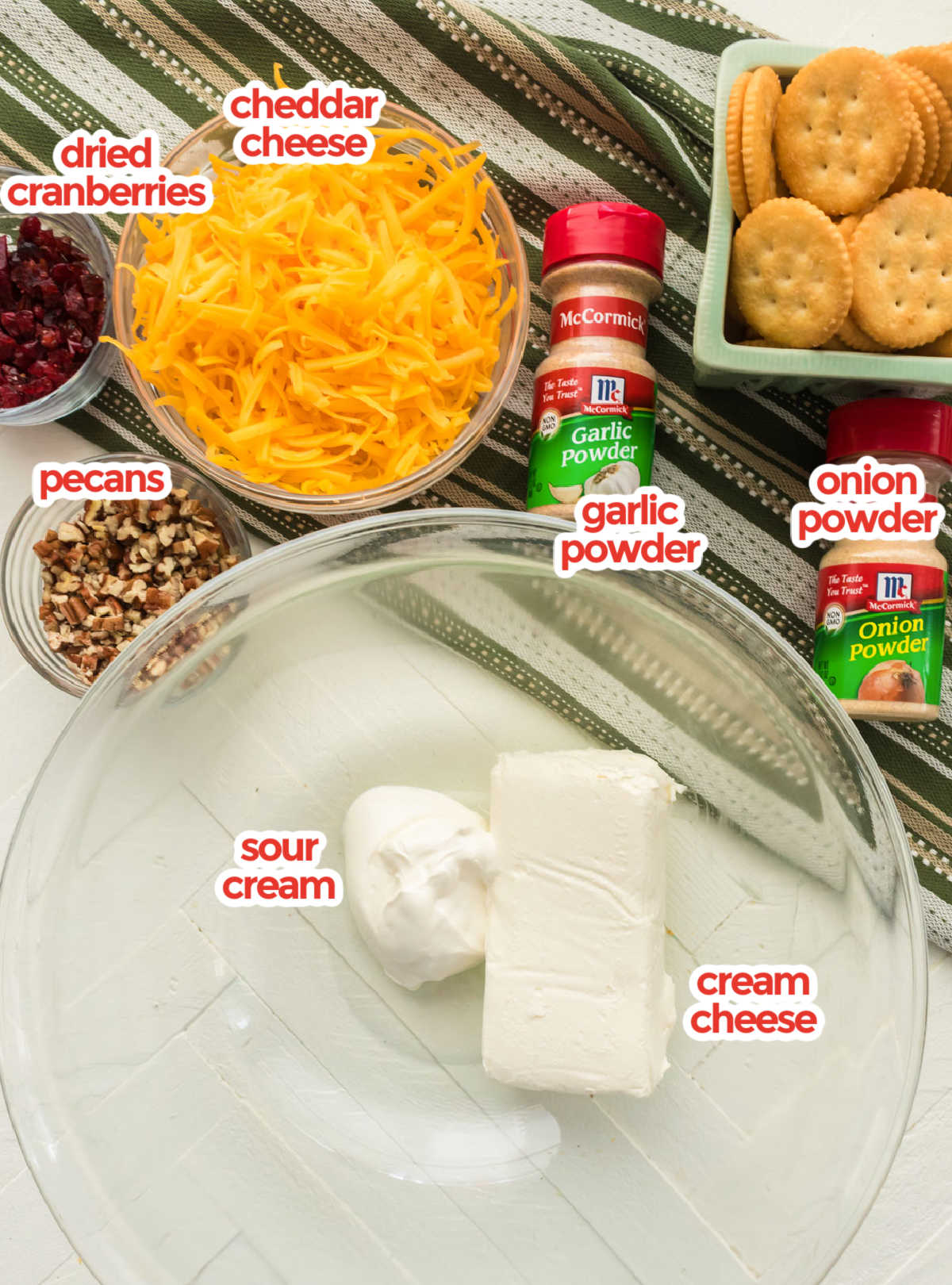 Showing all the ingredients needed to make Cheese Balls including Cream Cheese, Shredded Cheese, Pecans and Dried Cranberries.