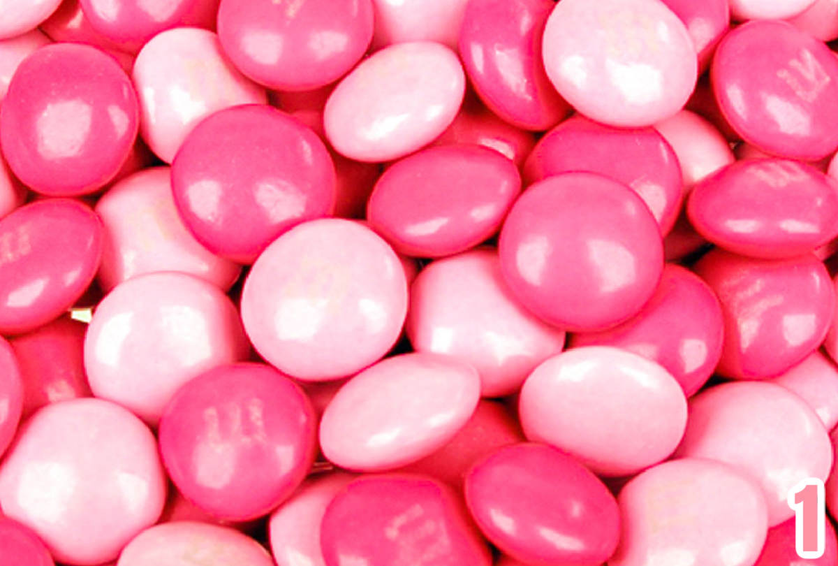 Closeup on a large pile of Dark and Light Pink M&M's.