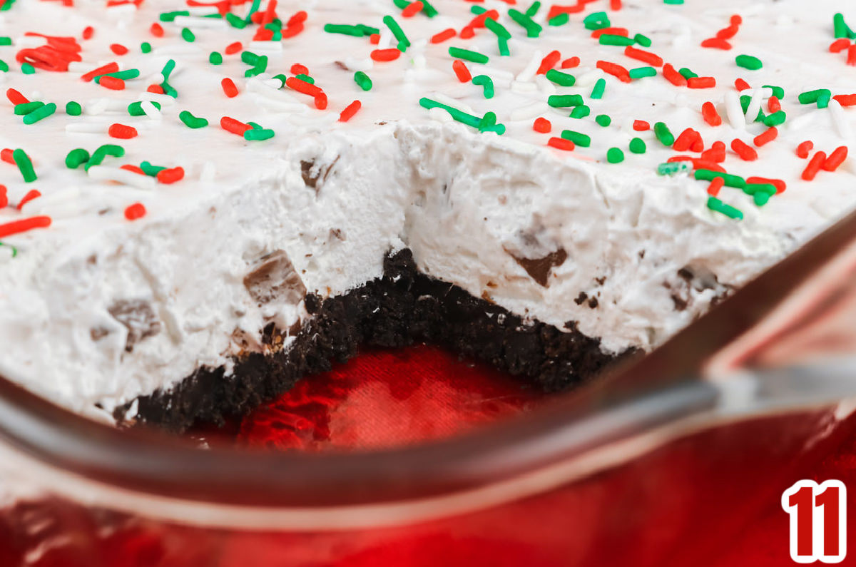 Closeup on a pan of Peppermint Marshmallow No-Bake Dessert with one piece removed.