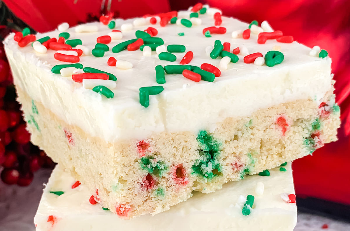 Closeup on a single Peppermint Sugar Cookie Bar sitting in front of a red background.