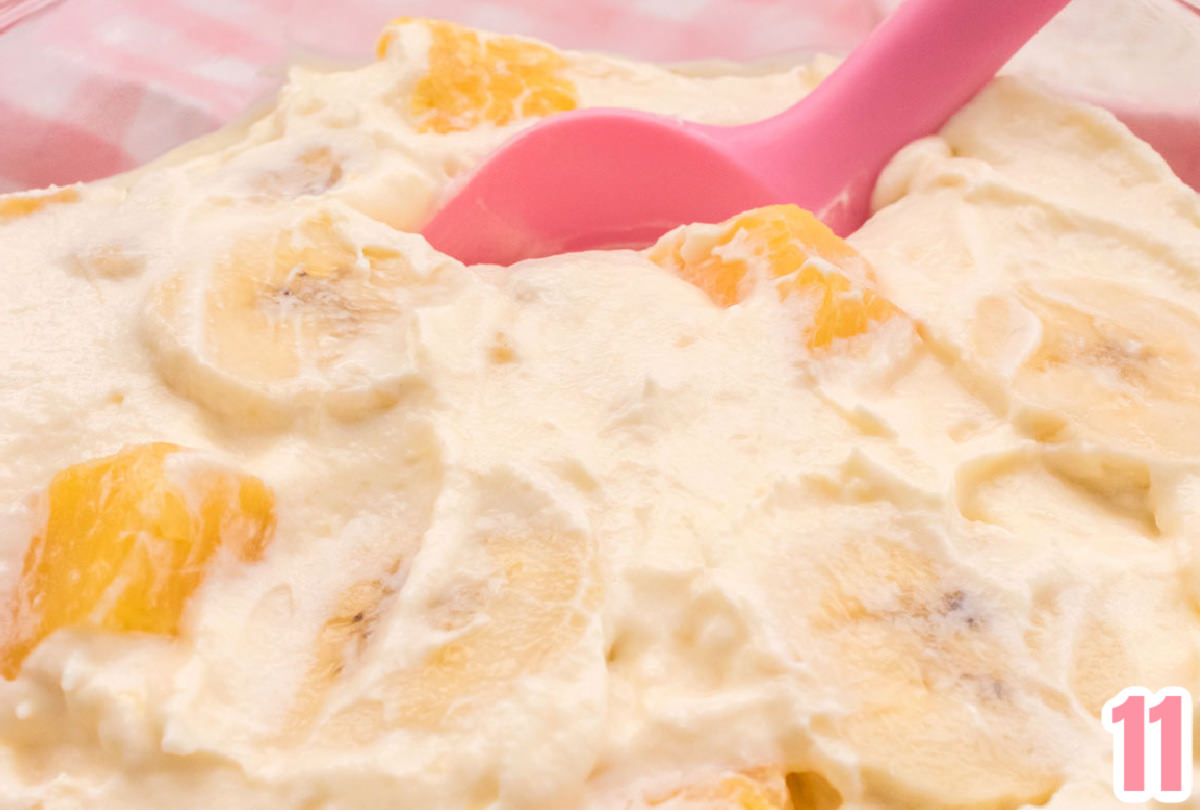 Closeup shot of Pineapple Banana Fluff showing pineapple and banana slices and a pink spatula.