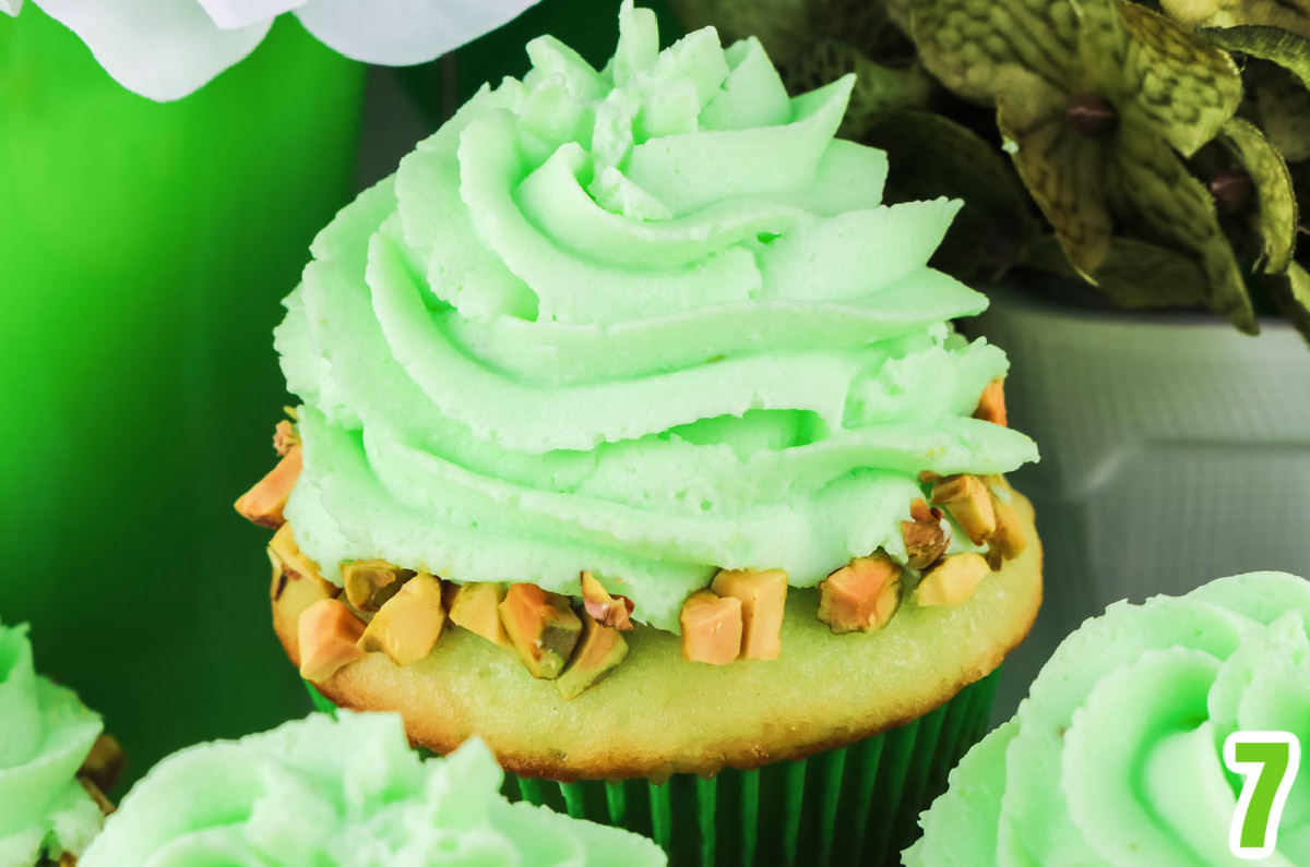 Closeup on a swirl of Pistachio Whipped Cream Frosting on a Pistachio Cupcake.