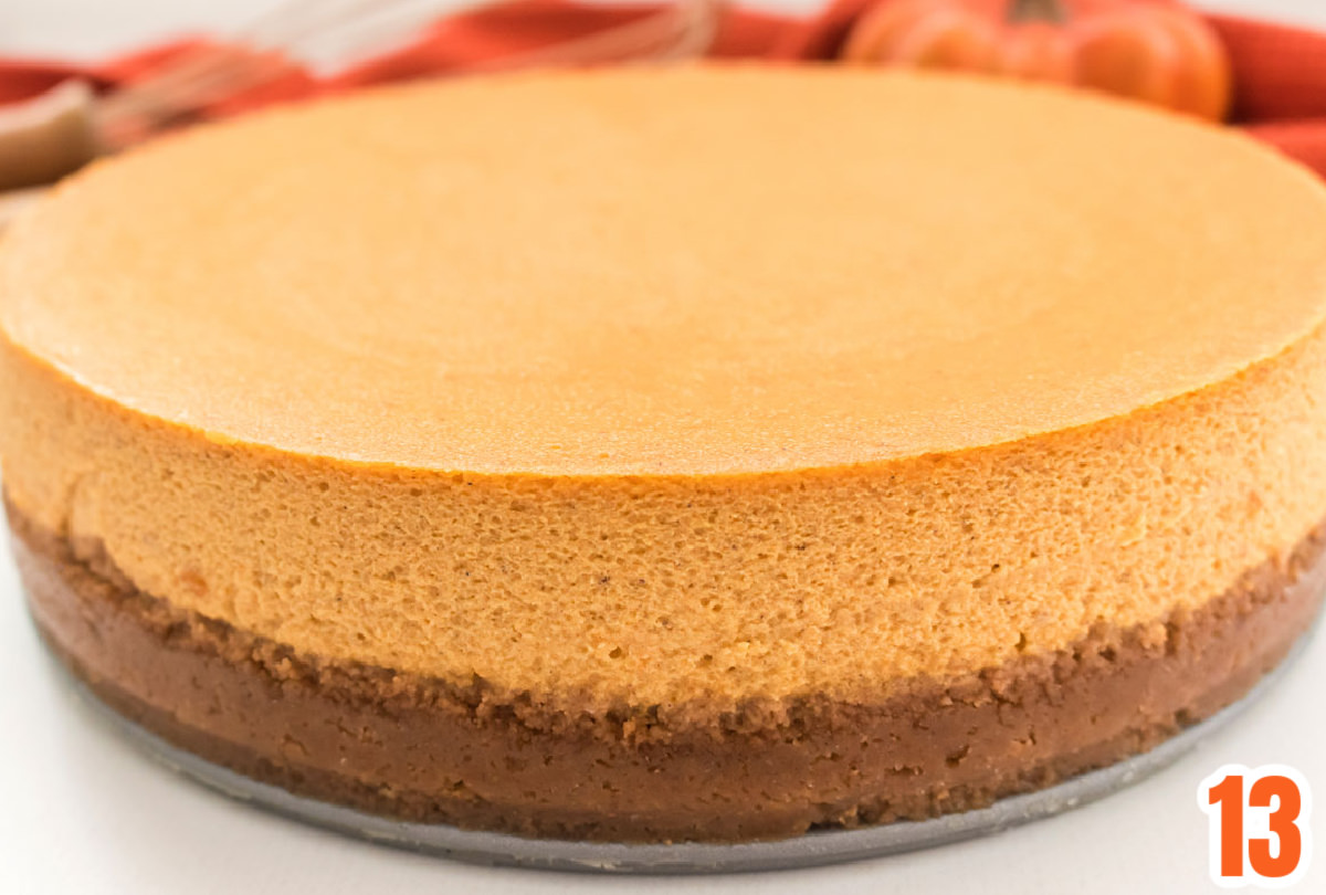 Closeup on a Pumpkin Cheesecake sitting on a white surface.