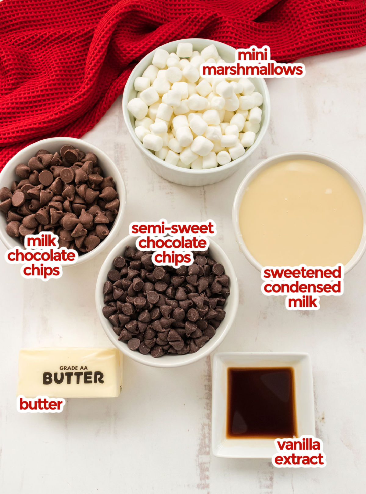 All the ingredients you will need to make Rocky Road Fudge including mini marshmallows, sweetened condensed milk, chocolate chips, butter and vanilla extract.