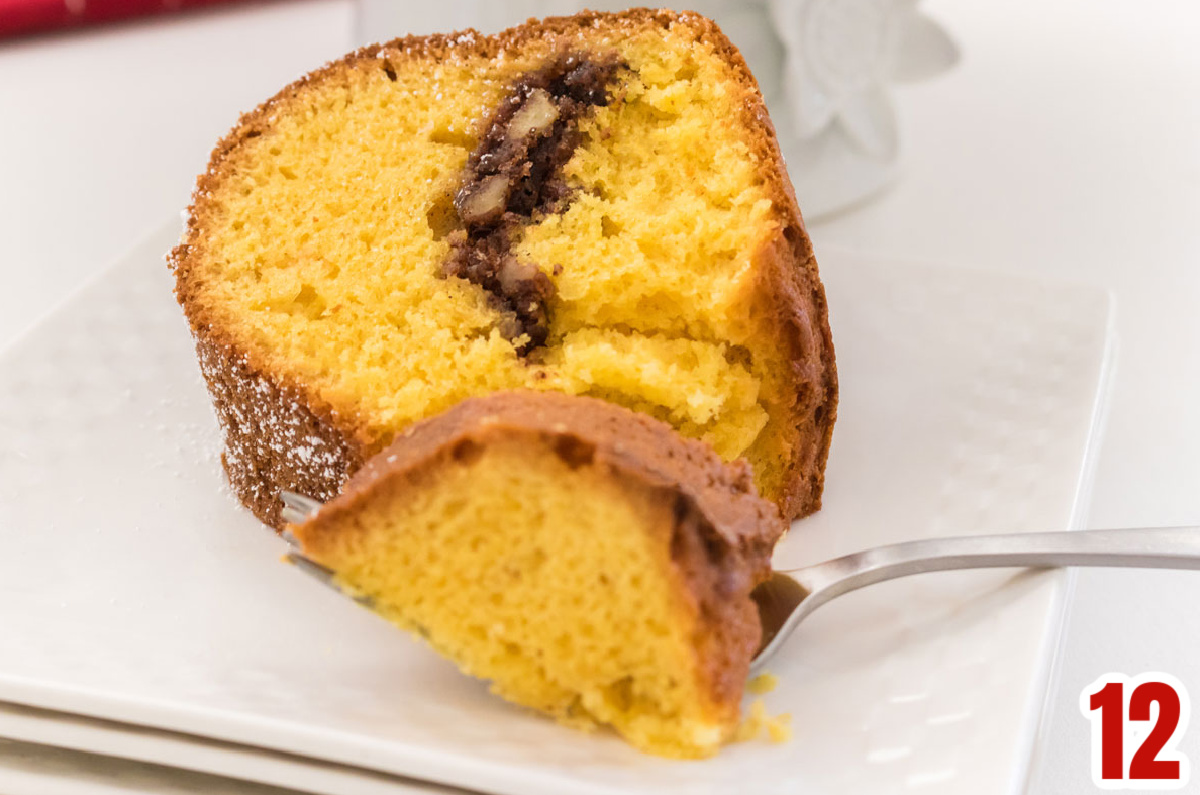 Closeup on a piece of Sherry Cake sitting on a white plate with a fork.