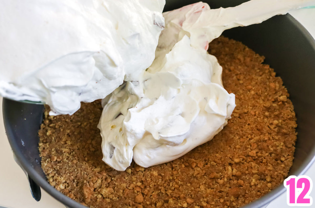 Pouring the marshmallow filling into the springform pan on top of the graham cracker crust.