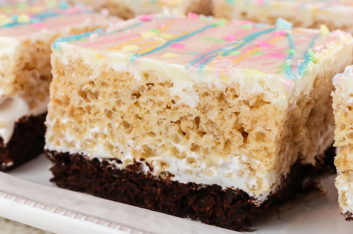 Close up of a Brownie Rice Krispie Treat sitting on a white serving platter.