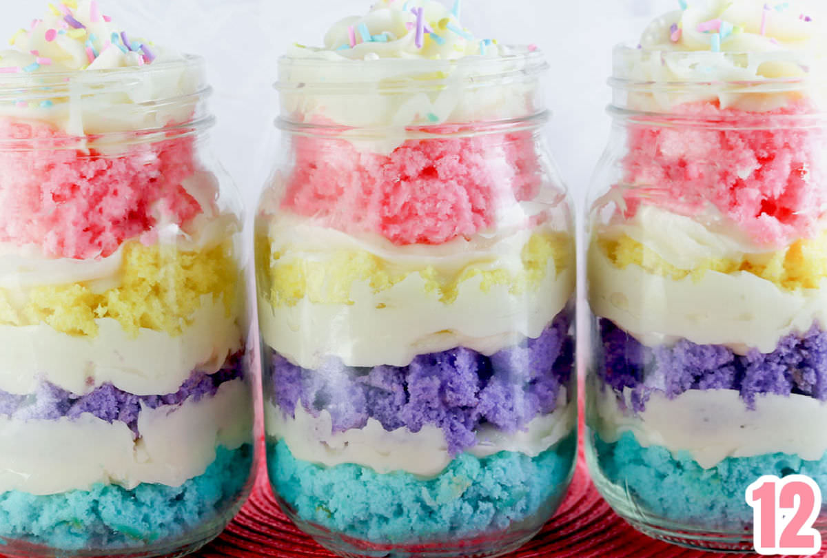 Close up on three Springtime Cupcakes in a Jar sitting in a row on a pink placemat.