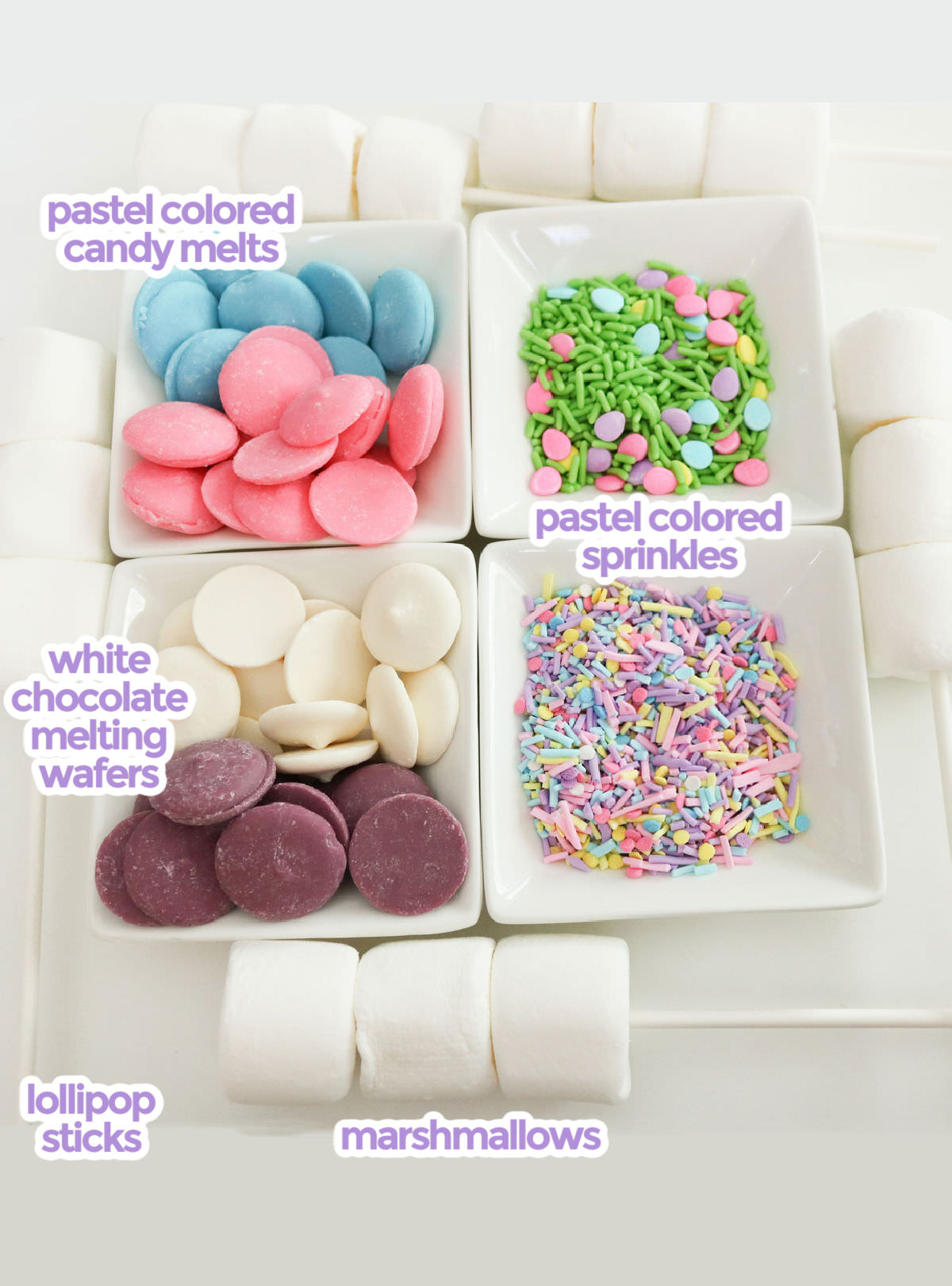 All the ingredients necessary to make Springtime Marshmallow Pops including marshmallows, lollipop sticks, candy melts, white chocolate and sprinkles.