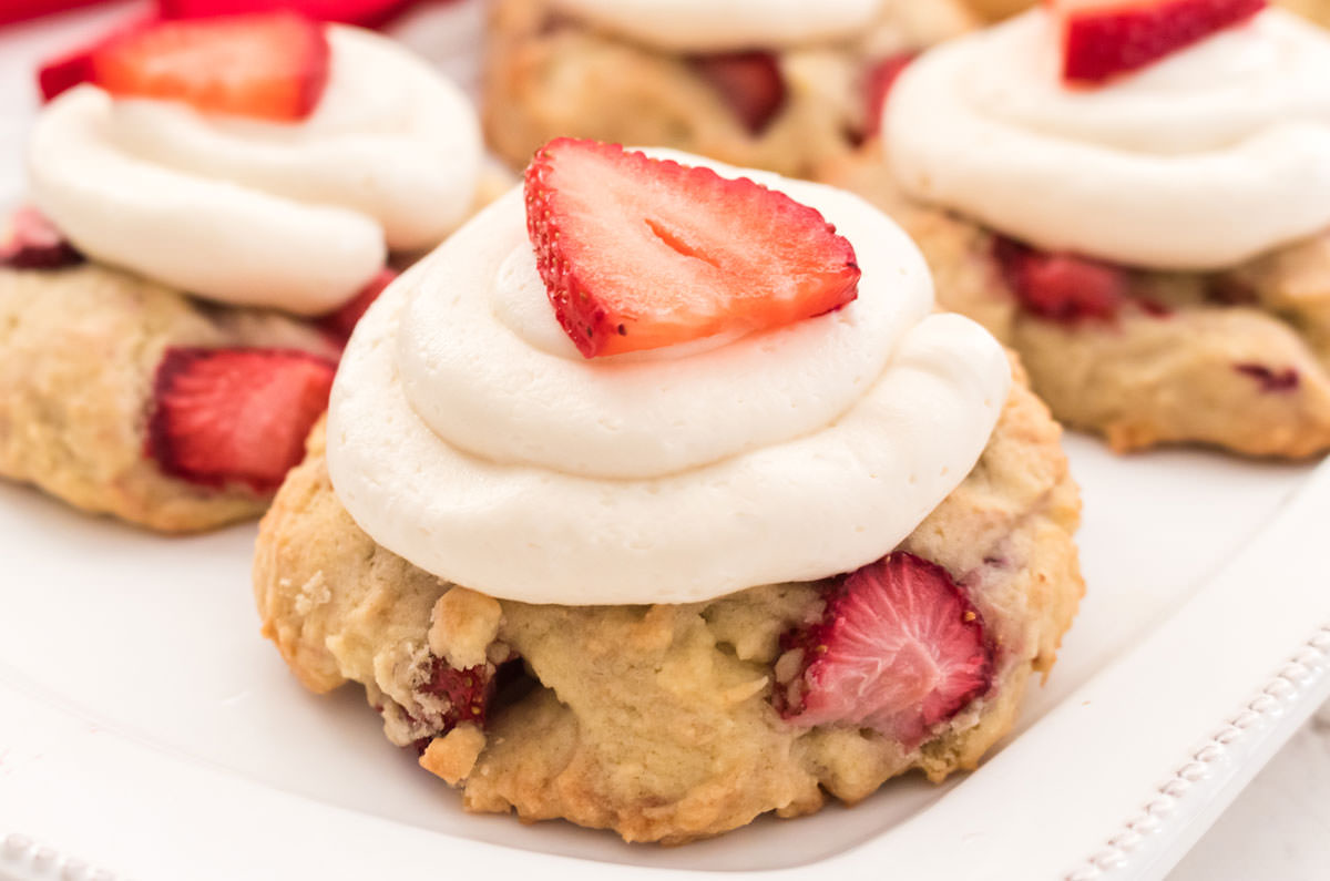 Closeup on a white plate with four Strawberry Shortcake Cookies.