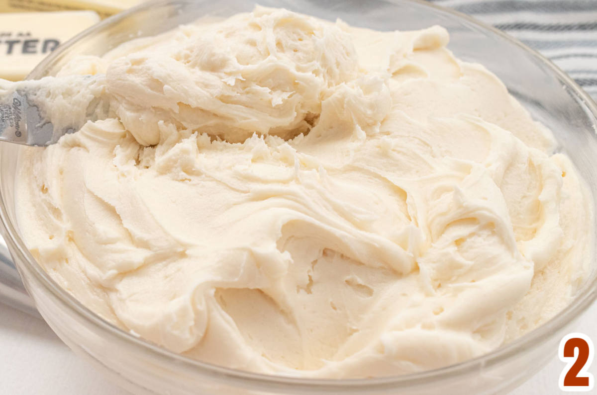 Closeup on a clear glass bowl filled with homemade Buttercream Frosting.