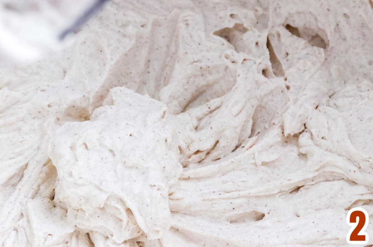Closeup on a mixing bowl filled with The Best Homemade Cinnamon Whipped Cream.