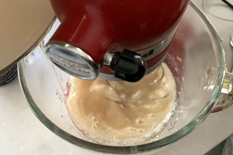 Pouring the simple syrup into the mixing bowl